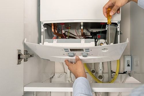 HVAC technician repairing an indoor boiler in Boulder