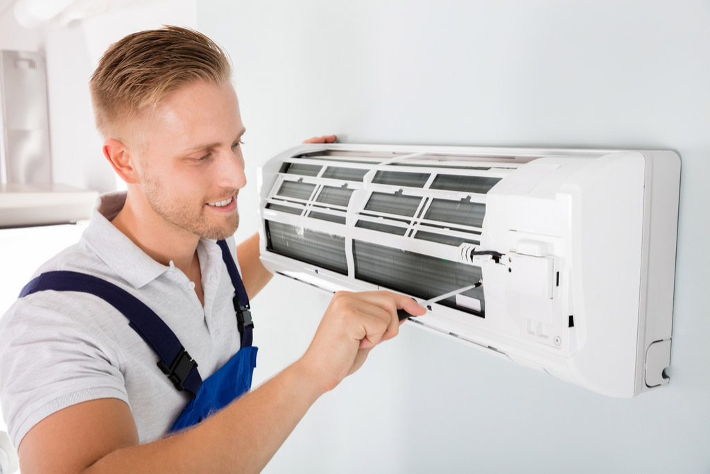 HVAC technician performing ductless air conditioning maintenance in Boulder