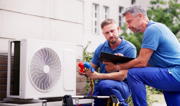 HVAC technicians installing an outdoor air conditioning unit in Boulder