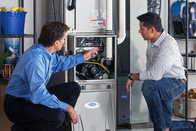65df8c11f3e4c468cbd351a5_furnace repair vs replacement – Copy HVAC technician explaining furnace repair and maintenance to a homeowner in Boulder, CO