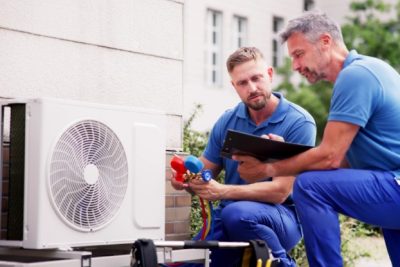 ac-installation-in-claremont-ca HVAC technicians reviewing an outdoor air conditioning unit in Boulder, CO