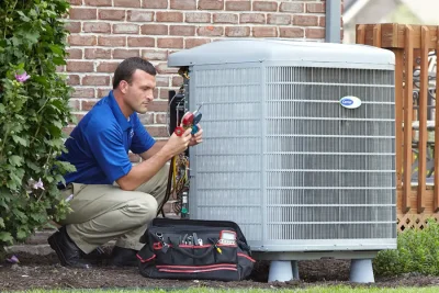 design-air-heating-and-air-conditioning-decatur-il-05 – Copy HVAC technician inspecting an outdoor air conditioning unit in Boulder, CO