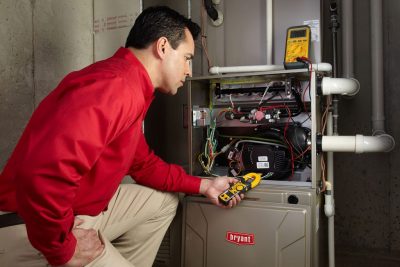 furnace repair Heating and air conditioning technician servicing an indoor furnace in Boulder, CO